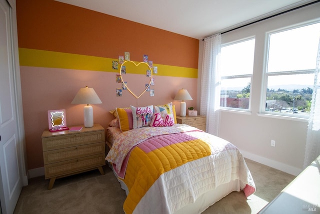 carpeted bedroom featuring baseboards and multiple windows