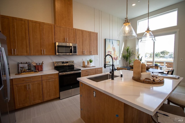 kitchen with a sink, light countertops, stainless steel appliances, and brown cabinets