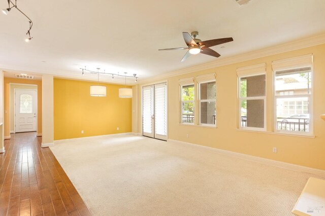 empty room featuring visible vents, rail lighting, ceiling fan, and ornamental molding