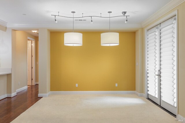 unfurnished room with crown molding, carpet flooring, baseboards, wood finished floors, and visible vents