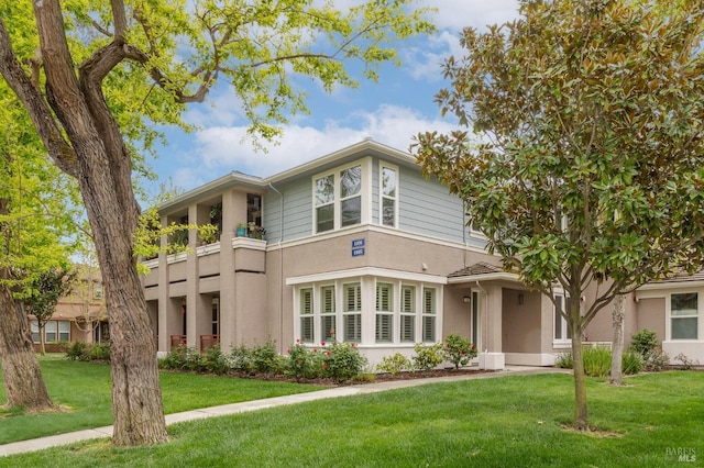 view of front of house with a front yard and stucco siding
