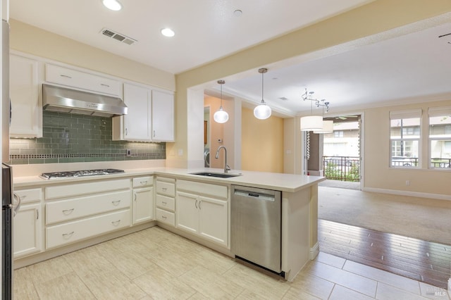 kitchen featuring backsplash, visible vents, appliances with stainless steel finishes, a sink, and ventilation hood