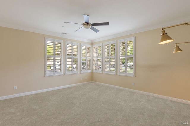 unfurnished room with baseboards, ornamental molding, carpet, and ceiling fan