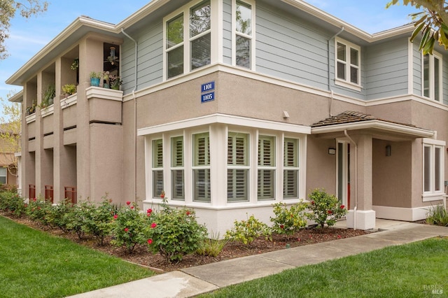 view of home's exterior with a lawn and stucco siding