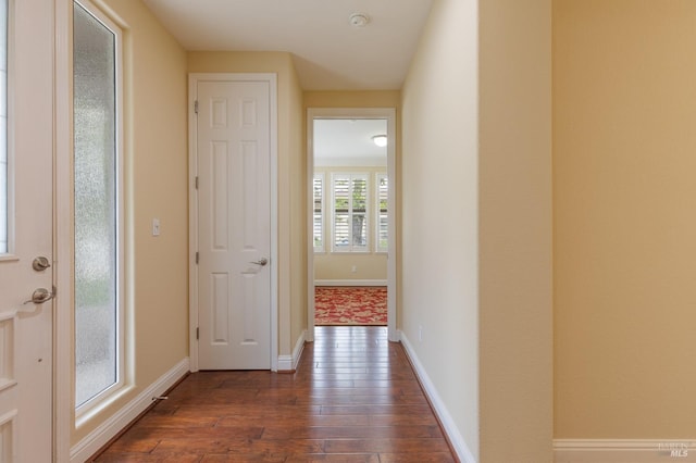 corridor with baseboards and dark wood-style flooring