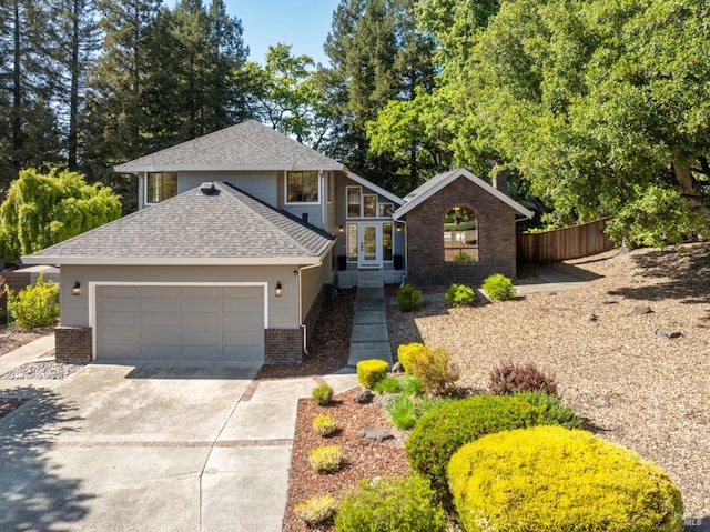 view of front of home with roof with shingles, brick siding, fence, concrete driveway, and an attached garage