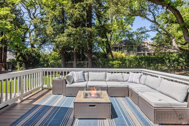 deck featuring an outdoor living space with a fire pit
