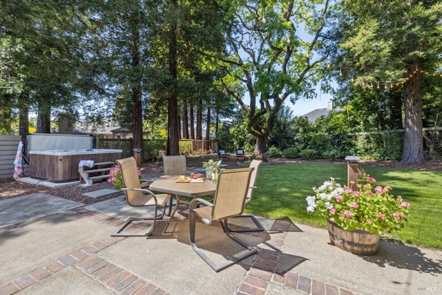 view of patio / terrace featuring a hot tub, outdoor dining space, and a fenced backyard