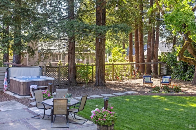 view of patio featuring a fenced backyard, a hot tub, and outdoor dining space