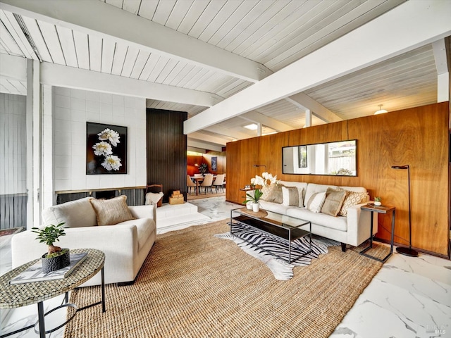 living room featuring wood walls, marble finish floor, and beam ceiling