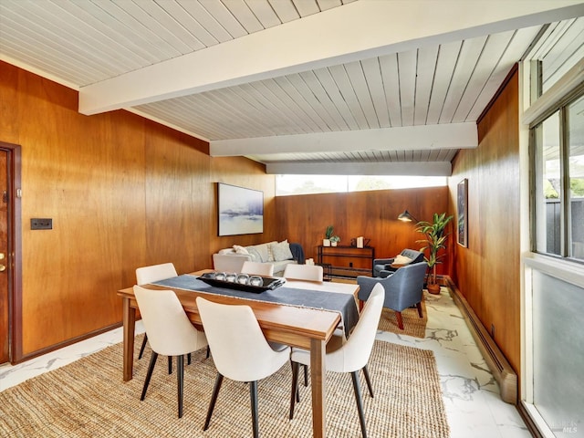 dining area with wooden walls, beamed ceiling, and marble finish floor