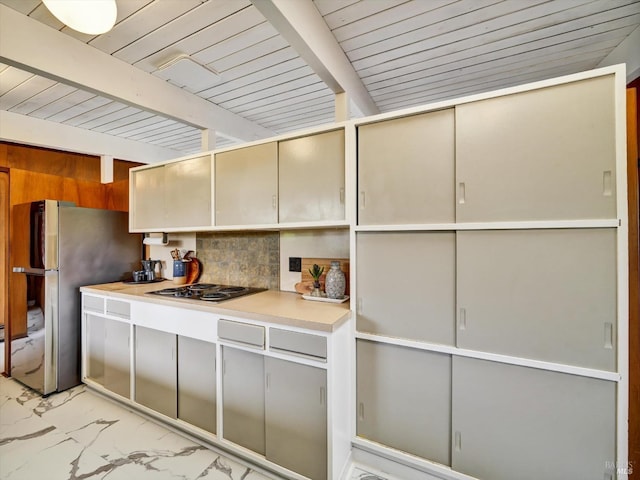 kitchen with freestanding refrigerator, marble finish floor, beamed ceiling, wood ceiling, and stovetop