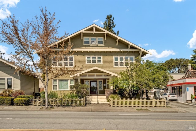 craftsman-style home with a fenced front yard