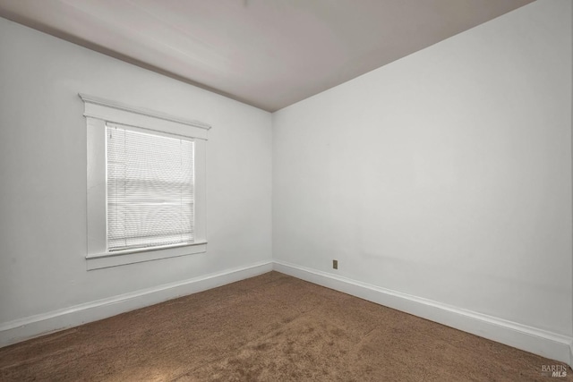 carpeted spare room featuring baseboards