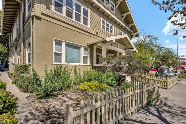 view of property exterior with fence and stucco siding