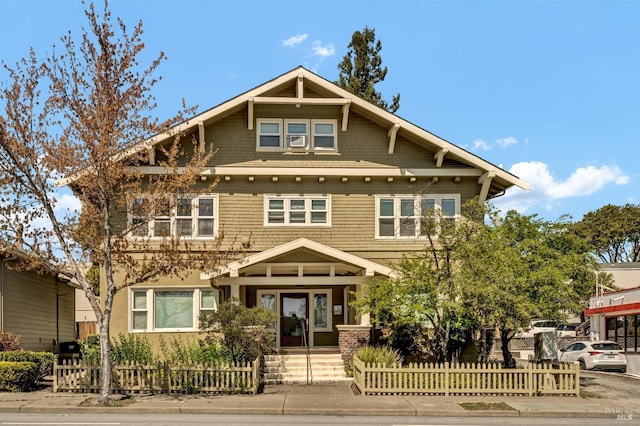 craftsman-style home featuring a fenced front yard