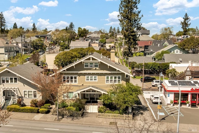 view of building exterior featuring uncovered parking, fence, and a residential view