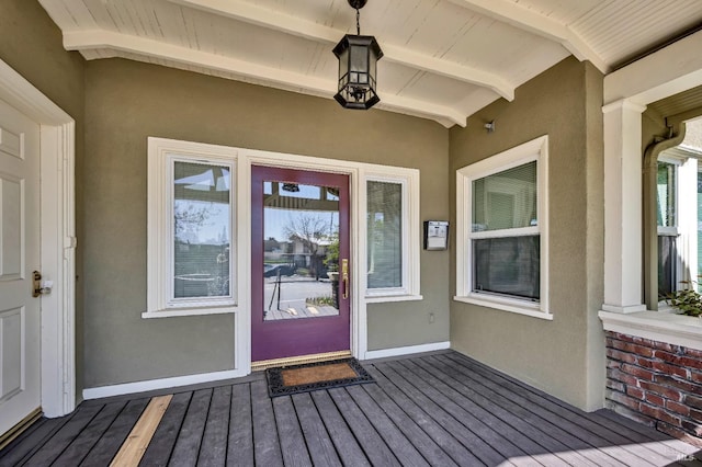 doorway to property with stucco siding and a wooden deck