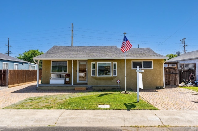 1034 Caldwell Ave, Vallejo, CA 94591 - view of front of house featuring a front lawn, fence, stucco siding, a shingled roof, and a porch