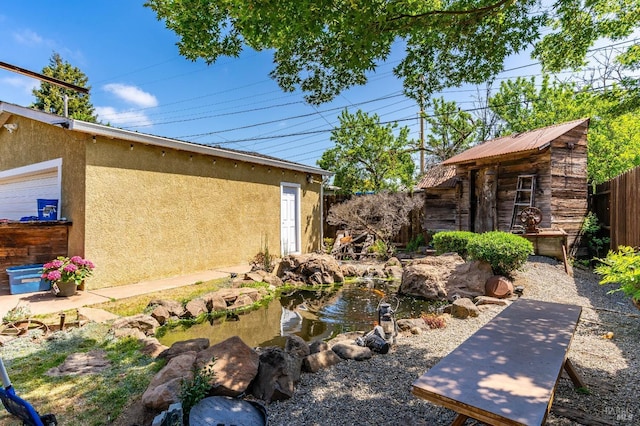 1034 Caldwell Ave, Vallejo, CA 94591 - view of yard with fence, a garden pond, an outbuilding, and a storage shed