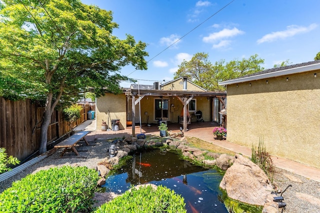 1034 Caldwell Ave, Vallejo, CA 94591 - rear view of property with a small pond, a patio, a fenced backyard, and stucco siding