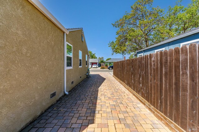 1034 Caldwell Ave, Vallejo, CA 94591 - view of property exterior with fence, a patio, stucco siding, and crawl space
