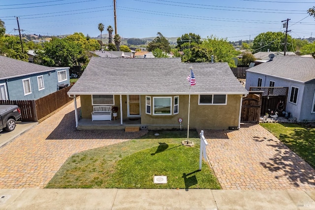 1034 Caldwell Ave, Vallejo, CA 94591 - ranch-style home featuring covered porch, a front yard, fence, a shingled roof, and stucco siding