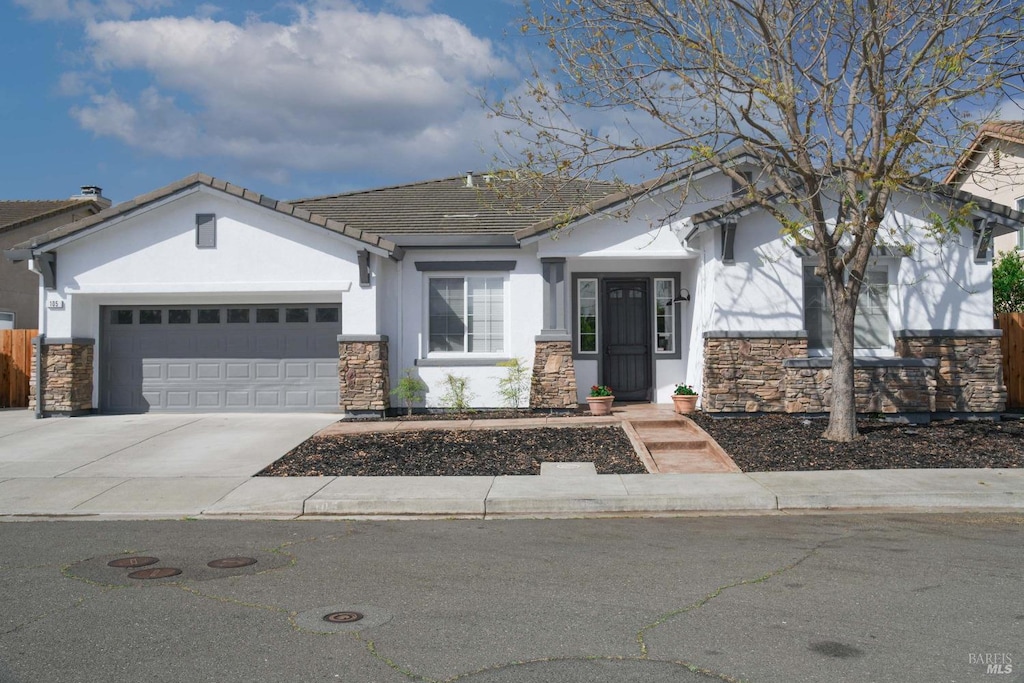 105 Red Clover Way, American Canyon, CA 94503 - view of front of house featuring stone siding, stucco siding, an attached garage, concrete driveway, and fence