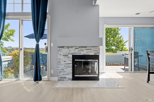 living room featuring a multi sided fireplace and wood finished floors