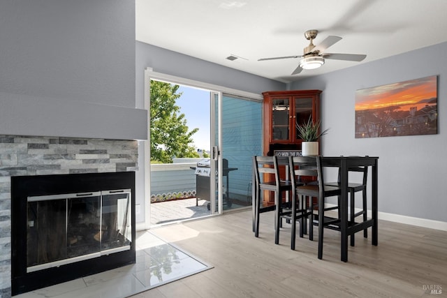 dining space with baseboards, ceiling fan, visible vents, and wood finished floors