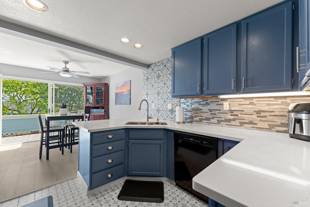 kitchen featuring a peninsula, black dishwasher, light countertops, a sink, and blue cabinetry