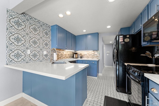 kitchen with a peninsula, blue cabinetry, decorative backsplash, and black appliances