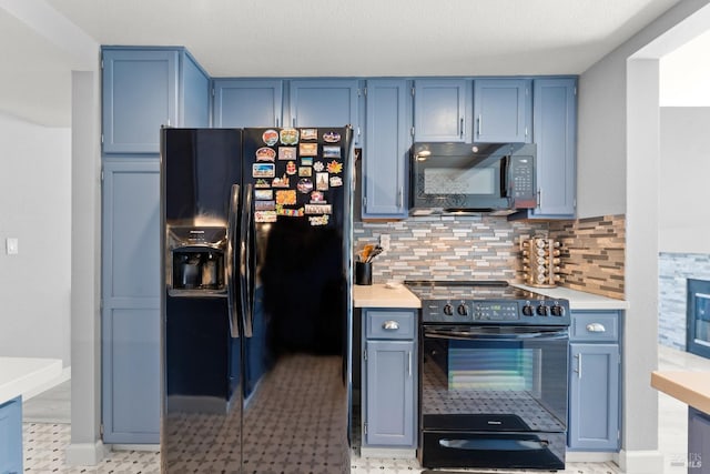 kitchen featuring light countertops, tasteful backsplash, black appliances, and blue cabinets