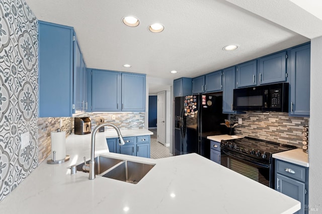 kitchen with backsplash, blue cabinetry, a sink, light countertops, and black appliances