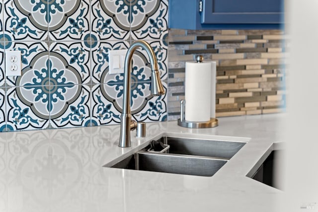 details with light countertops, blue cabinetry, a sink, and tasteful backsplash