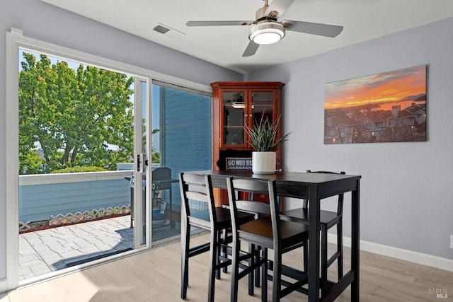 dining area featuring light wood-style floors, baseboards, ceiling fan, and visible vents