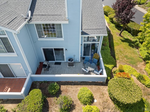 rear view of property featuring roof with shingles, a patio, and a balcony