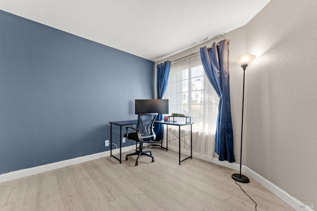 office space featuring baseboards, a textured wall, and wood finished floors