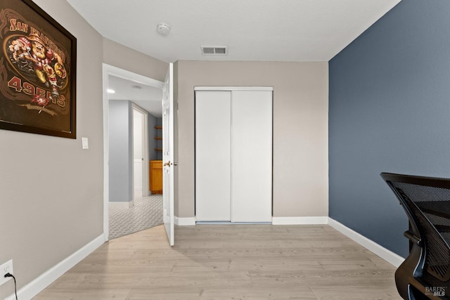interior space featuring visible vents, light wood finished floors, baseboards, and a closet