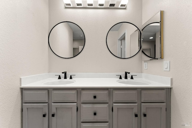 full bathroom with double vanity and a sink