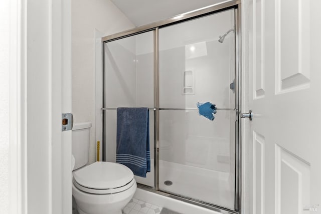 bathroom with a stall shower and toilet