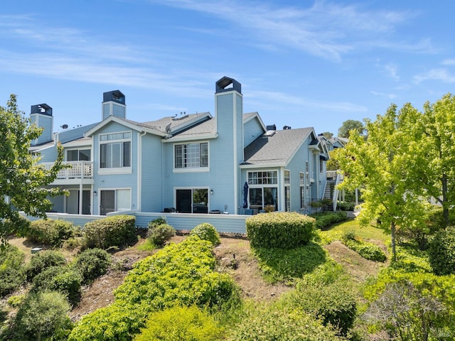 back of house featuring a chimney