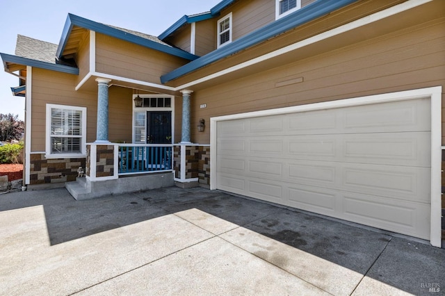 1216 Hermitage Way, Rohnert Park, CA 94928 - view of exterior entry featuring concrete driveway, stone siding, a porch, and a garage