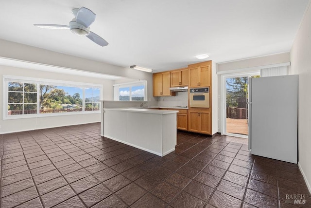 kitchen featuring light countertops, a sink, a wealth of natural light, and white appliances
