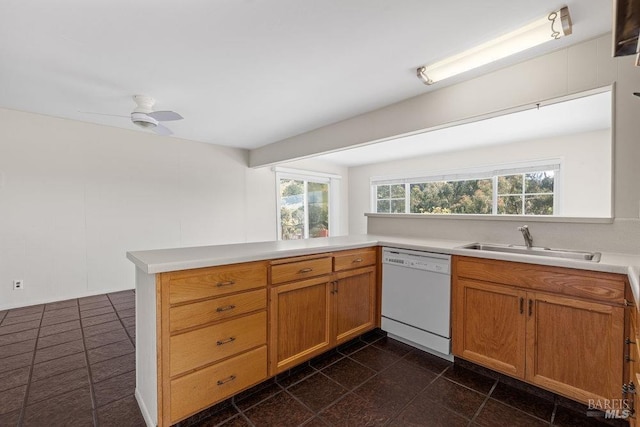 kitchen with a peninsula, ceiling fan, light countertops, a sink, and dishwasher