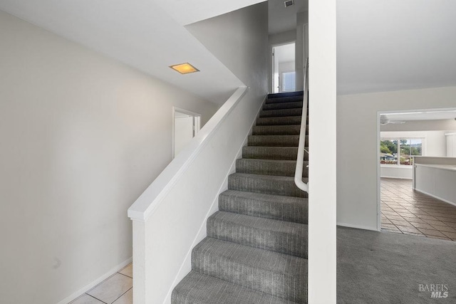 stairs with tile patterned floors, baseboards, carpet floors, and visible vents