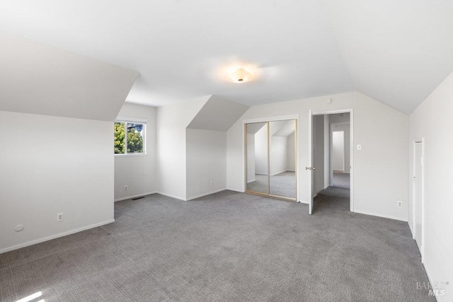 bonus room featuring carpet floors, baseboards, visible vents, and lofted ceiling
