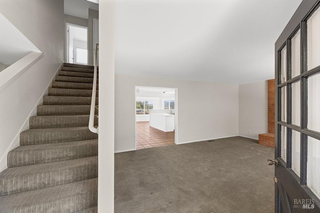 stairs featuring baseboards and carpet