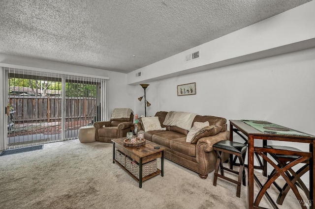 carpeted living room with a textured ceiling and visible vents
