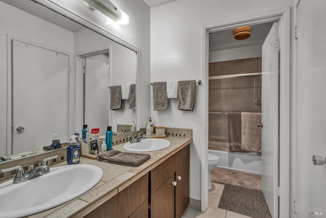 bathroom featuring double vanity, a sink, bath / shower combo with glass door, and toilet